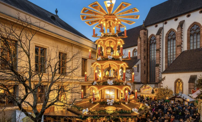 Holiday decorations and lights across the buildings with the Strasbourg Capitale de Noel sign light up for the night time Christmas markets