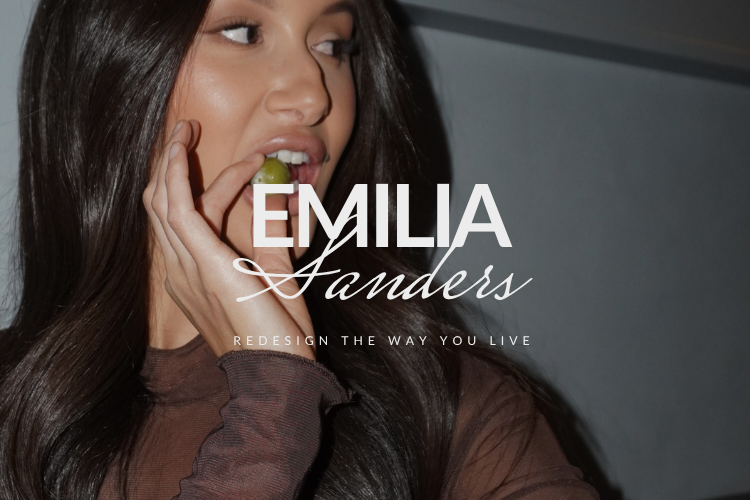 Emilia Sanders logo and tagline “Redesign the Way You Live” over editorial-style photo of woman eating a grape