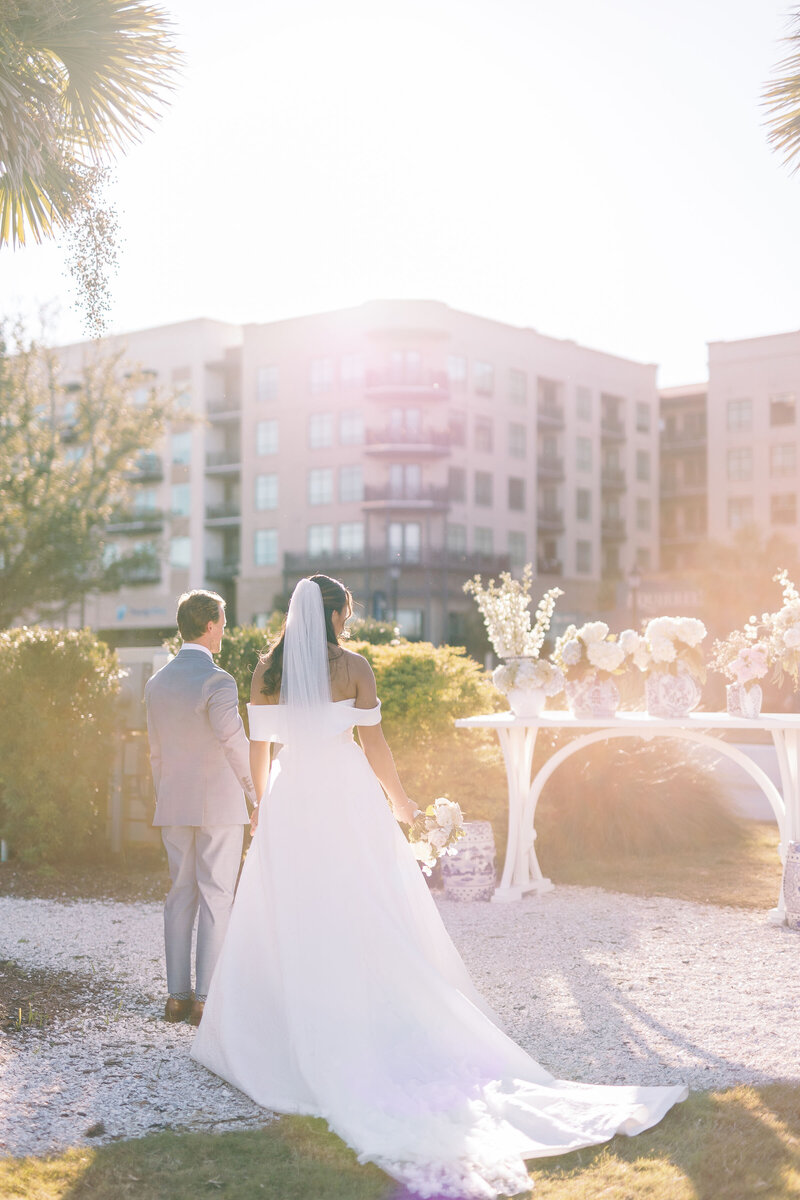 Bride and groom holding hands with bouquet
