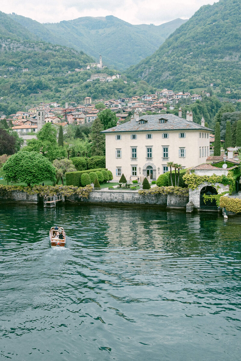 Aerial drone photo of boat ferrying a bride & groom to their wedding venue villa balbiano on the shores of lake como