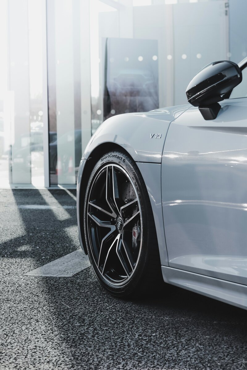 Front bumper and wheel of expensive white car