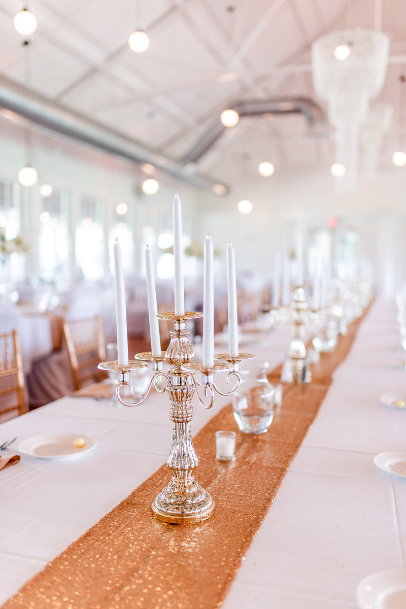 White with gold accent candelabra and votive candles at a wedding reception