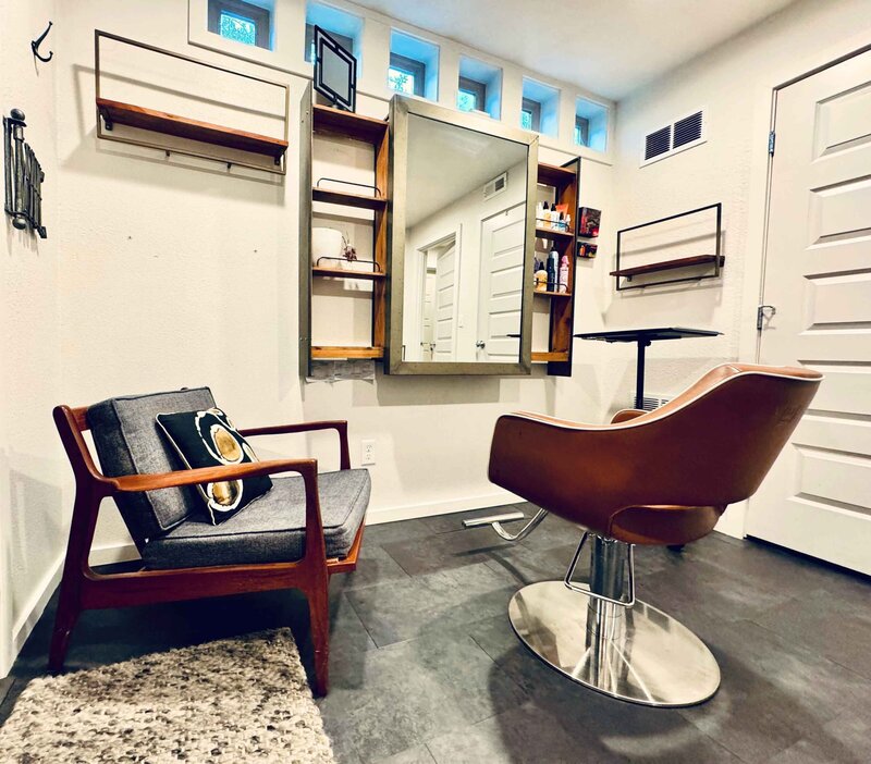 Private hair salon with chairs and mirror.