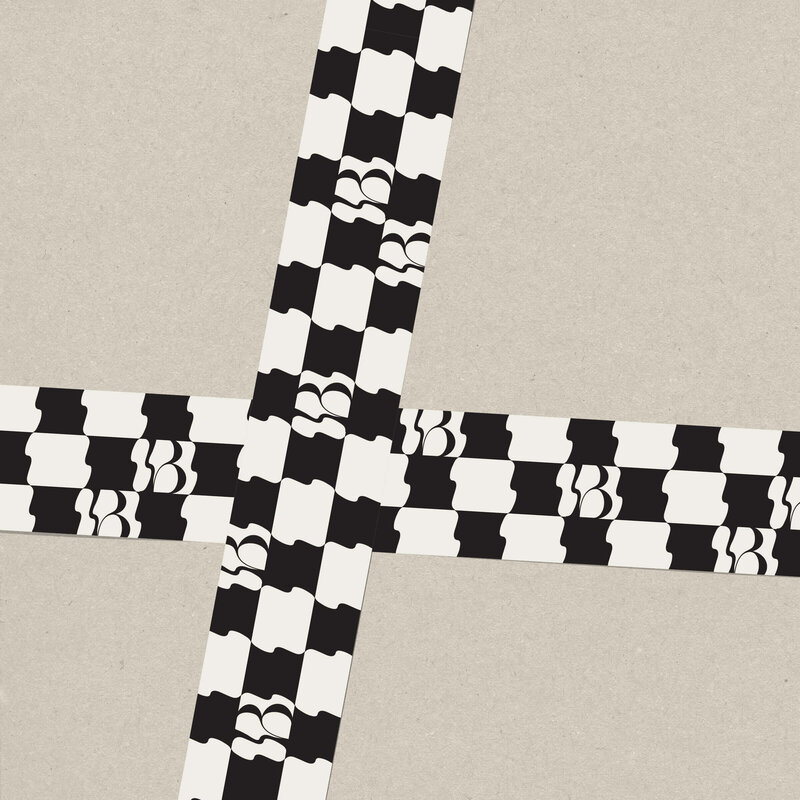 Bespoke Lane & Co. gift wrap featuring a bold black-and-white checkered design with the brand’s logo. The wrapping reflects the brand’s modern and artistic approach to luxury gifting, adding a unique touch to the packaging.