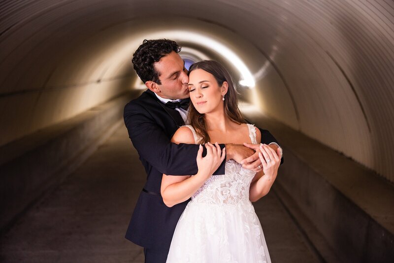 A bride and groom embrace in Talega Golf Club's unique tunnel on their San Clemente wedding day.