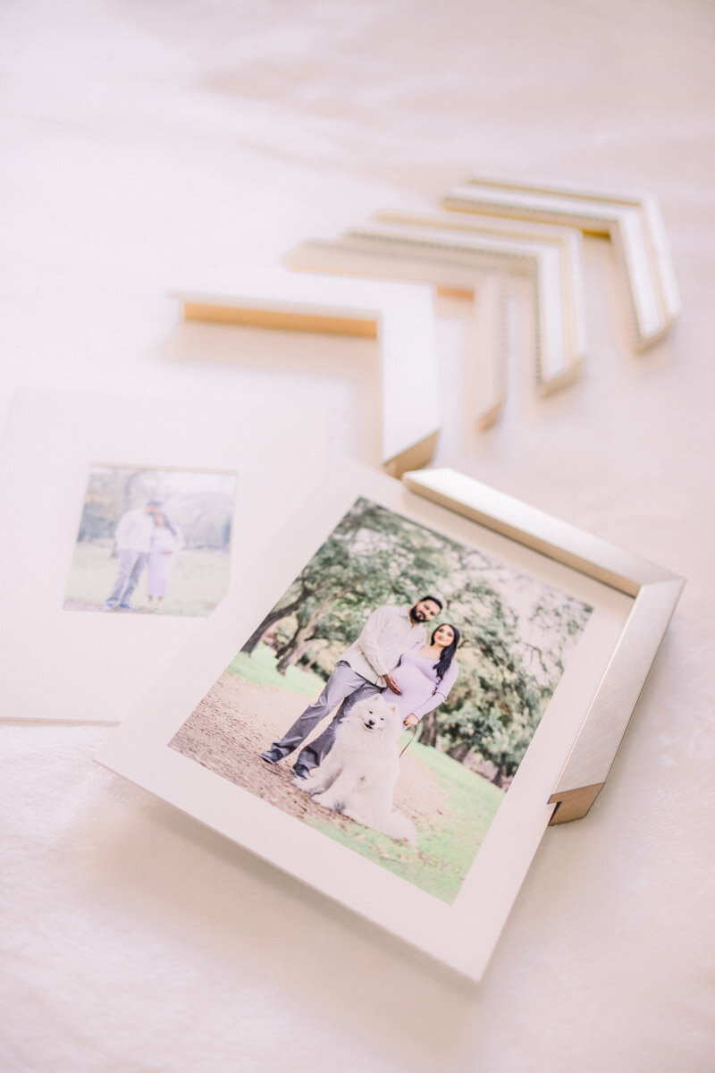 Mounted prints of photos from a maternity photoshoot displayed along with frame corners for designing wall art