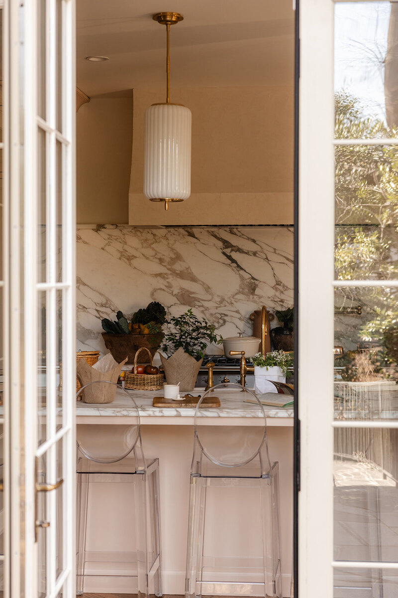 Looking through French doors into a bright, modern kitchen styled for wellness and nourishment