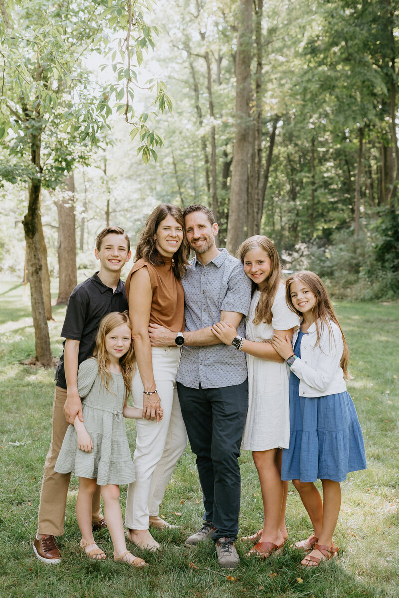 A family of six poses for an outdoor photo with Lafayette, Indiana family photographer Vanessa Stoller. 