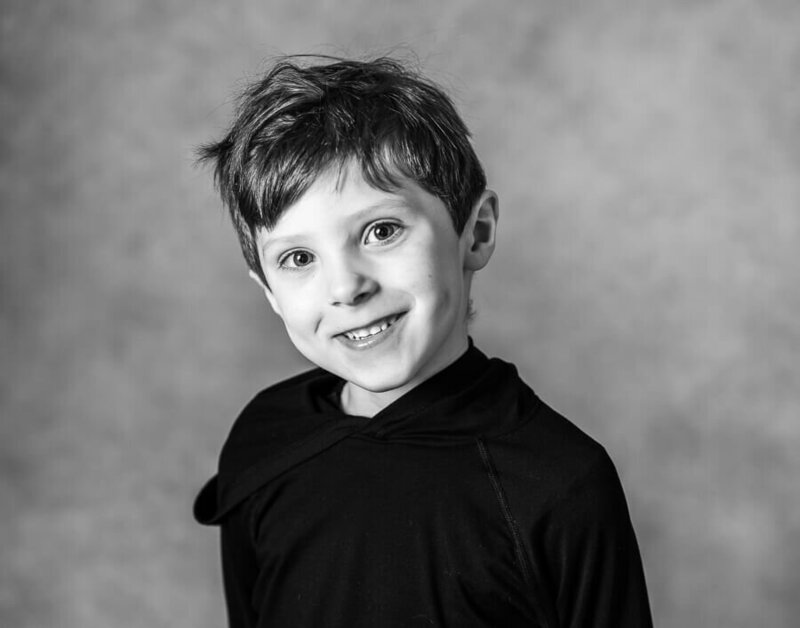A kid, with their head to the side, smiling.