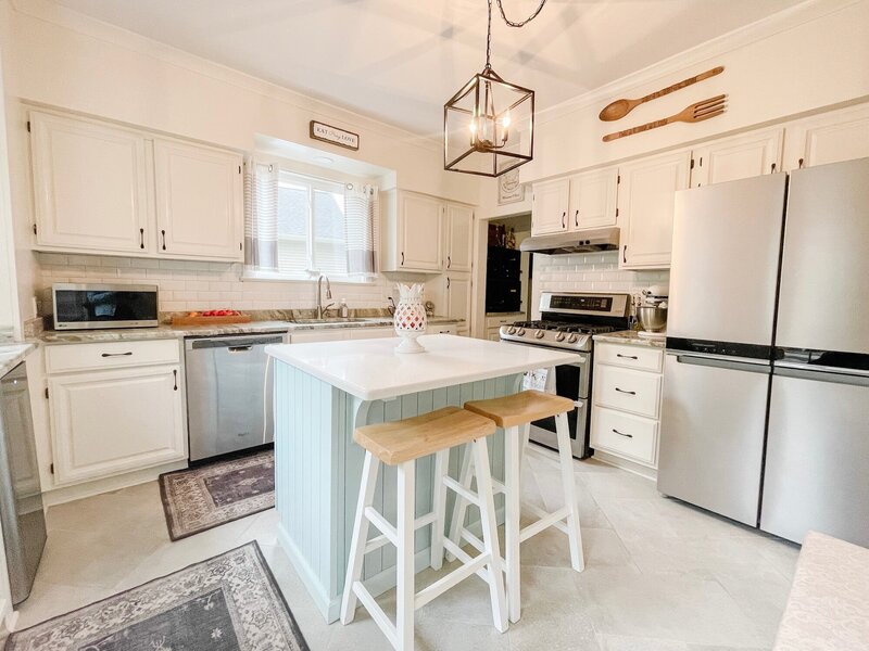 Bright kitchen with white cabinets and a light blue kitchen island.