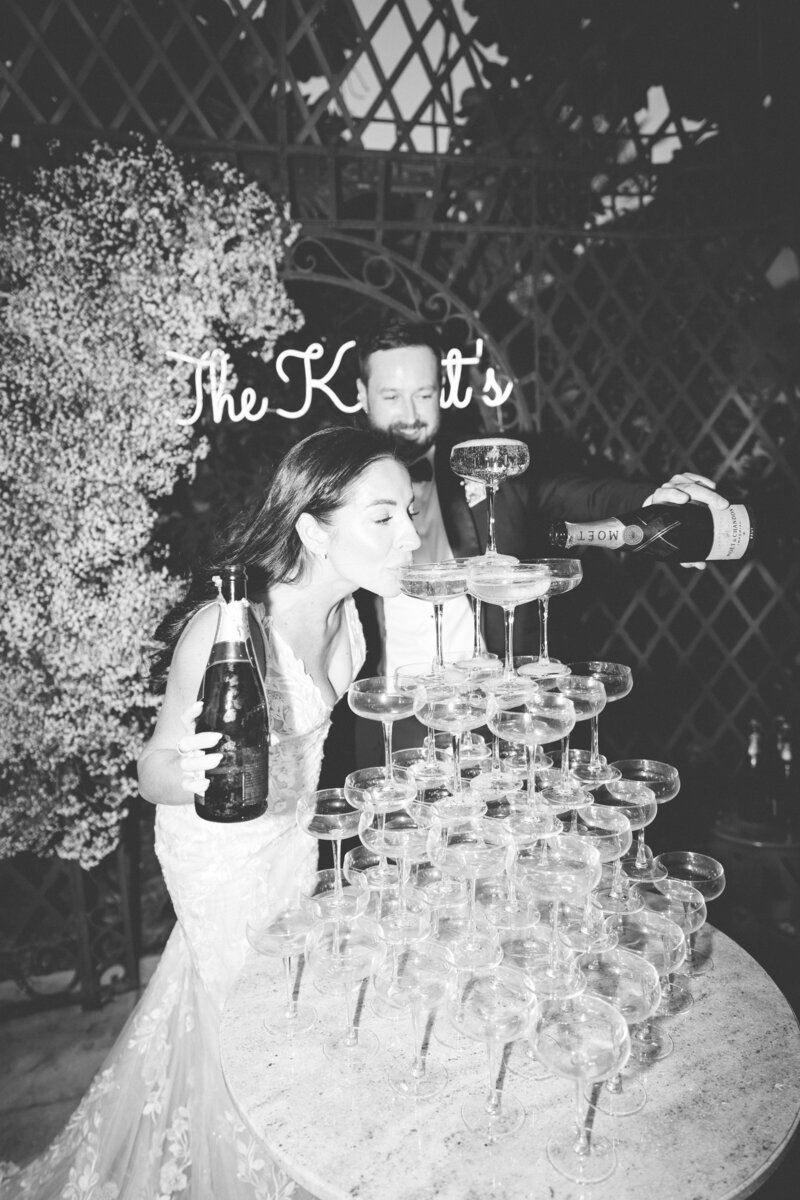 A couple drinking from a champagne tower at a wedding in Dubai