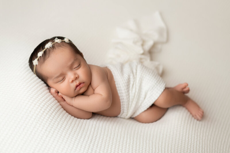 Baby sleeping in a comfortable white blanket