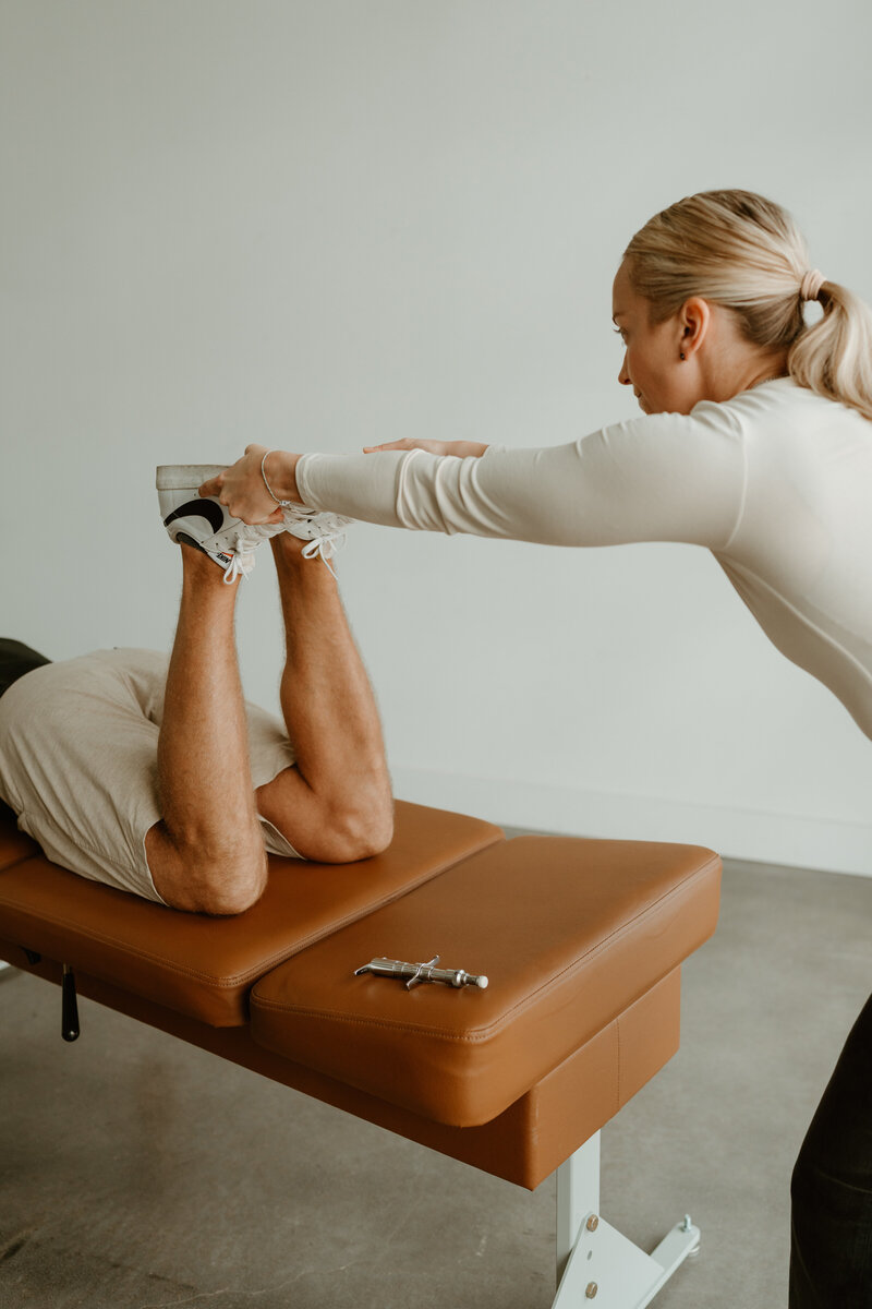 woman adjusting adult man on chiropractic table