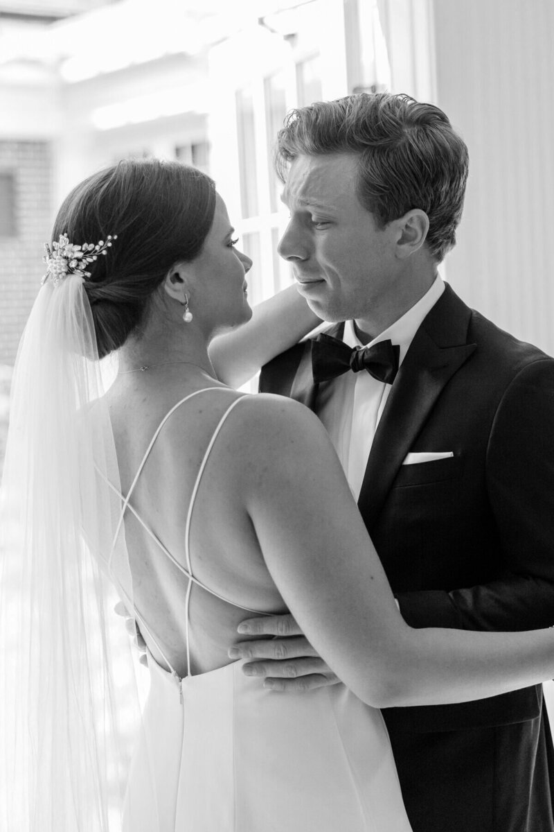 Candid photo of groom crying during their first look at the Grosse Pointe Yacht Club.