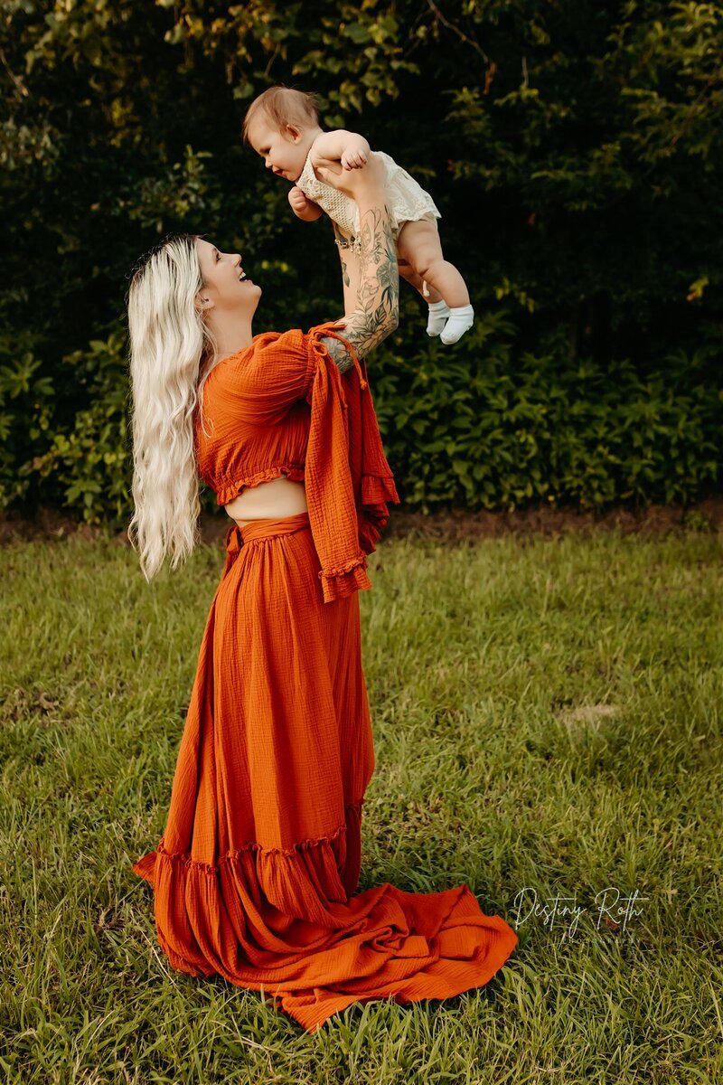 Family photography session in Cleveland TX with Destiny Roth lifting her daughter outdoors