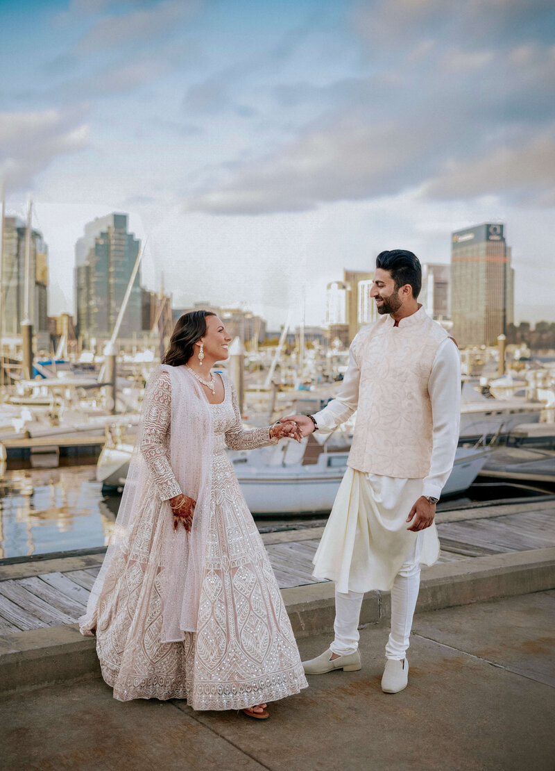 cheerful-muslim-bride-and-groom-waterfront-city