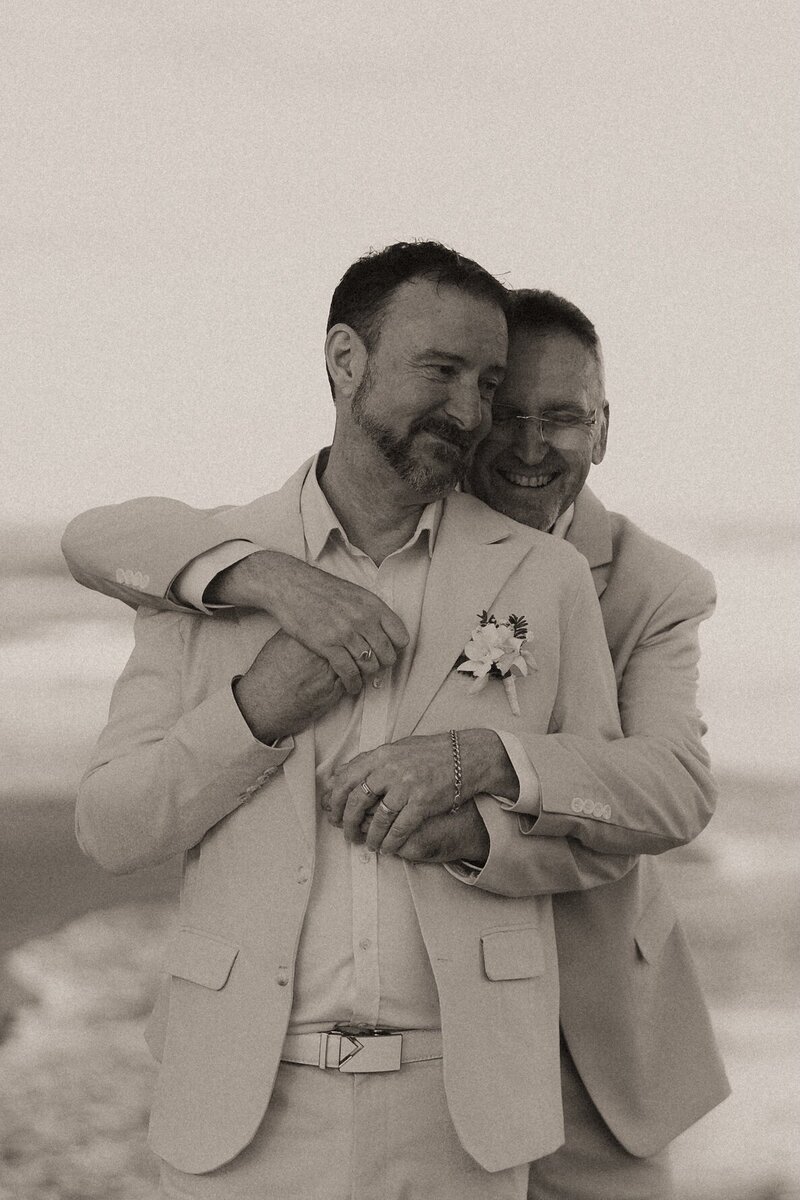 A heartfelt wedding portrait take in Urunga, with a close up of the bride and groom cuddled together holding hands