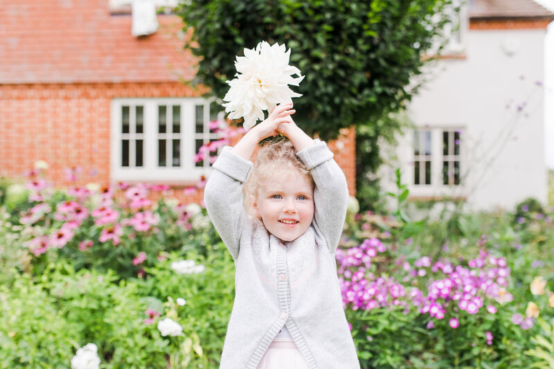 girl holding flower up in english garden