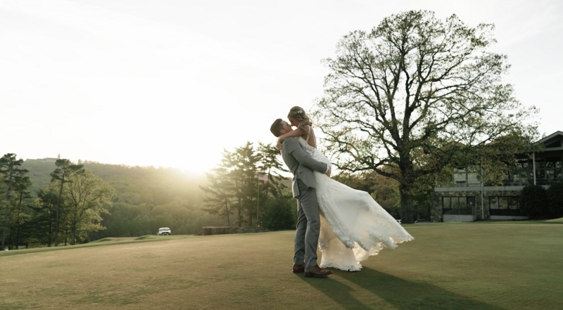 groom lifts bride and kisses her