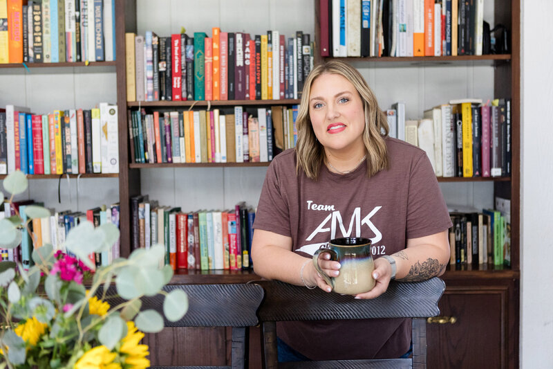 Ashley in her home office with a cup of coffee