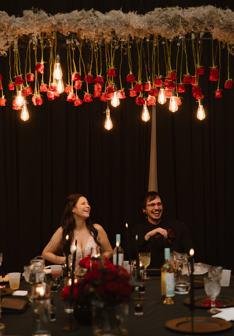 A wedding with a black and red theme, featuring the couple at their head table in the August House Venue.