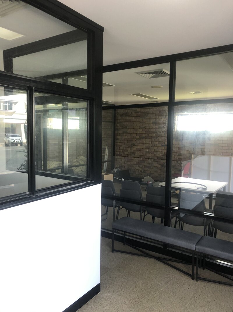 Modern office space featuring custom glass partitions, designed for privacy and a professional appearance.