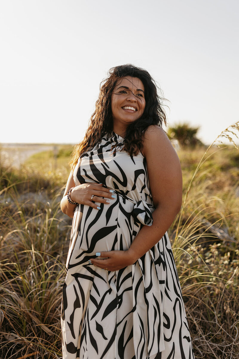 gainesville fl maternity photo pregnant mom holding baby bump next to beach