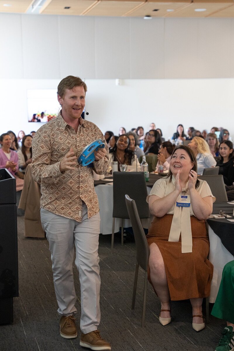 Daniel walking among smiling conference participants during an interactive keynote