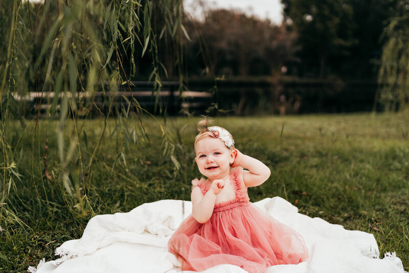 A baby sitting on a blanket.