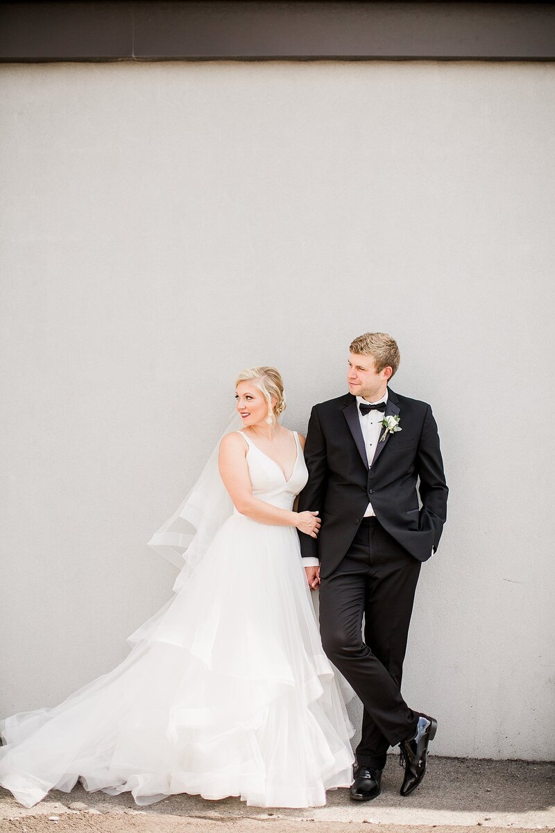 couple in front of neutral wall by Knoxville Wedding Photographer, Amanda May Photos