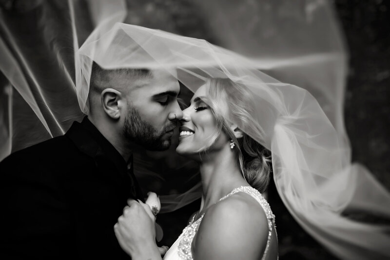 black and white phtoto of a couple embracing with a veil around them Oregon Coast Elopement and Wedding Photographer