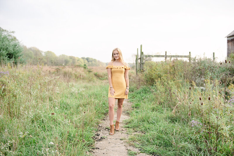 Girl standing in a field at a senior session in Medina Ohio