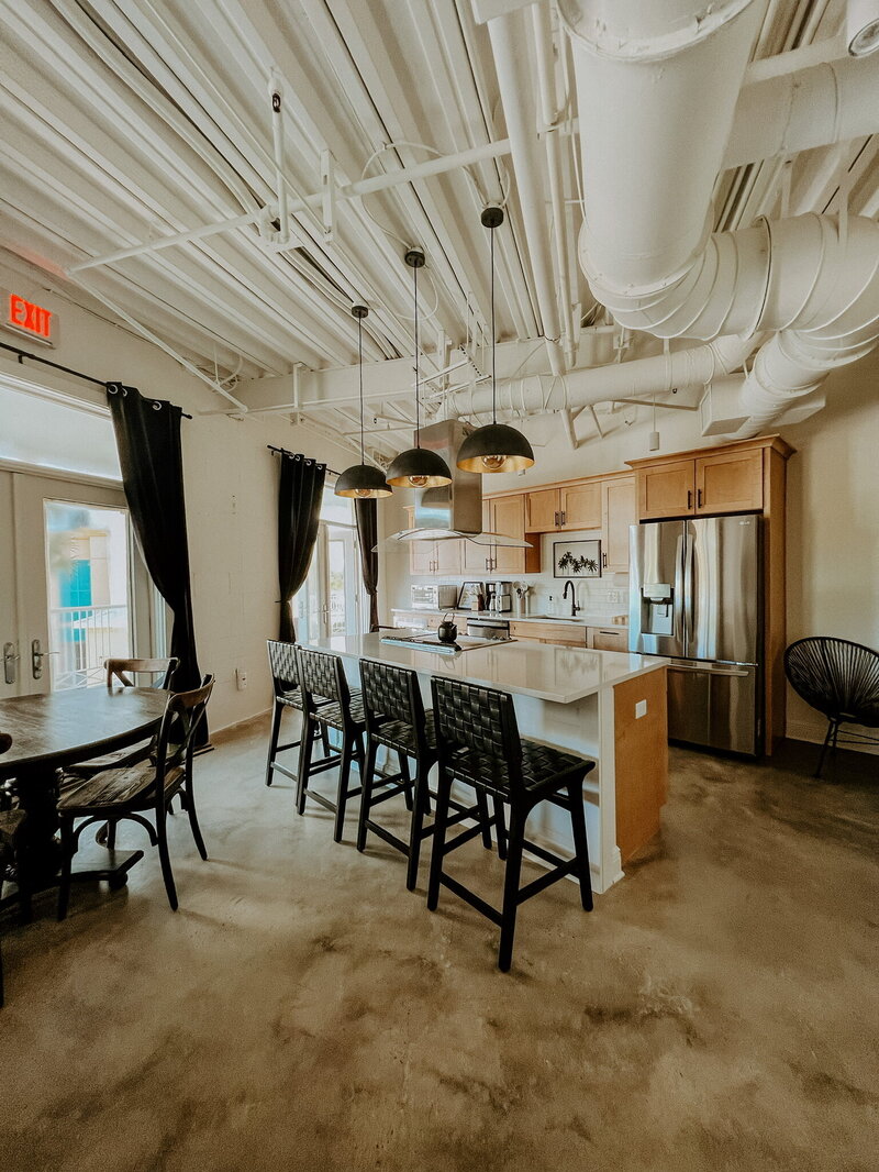 modern black and white kitchen with concrete floors and exposed cielings