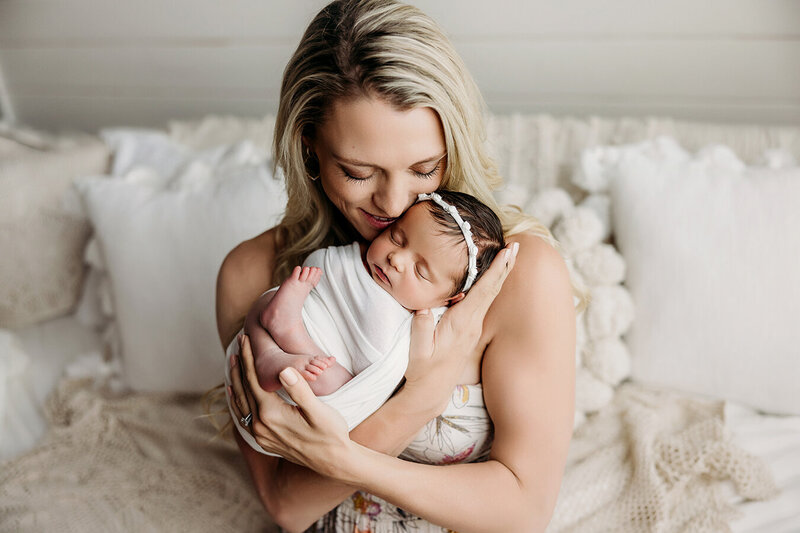 Mom holds her brand new baby in Fort Collins area photography studio.