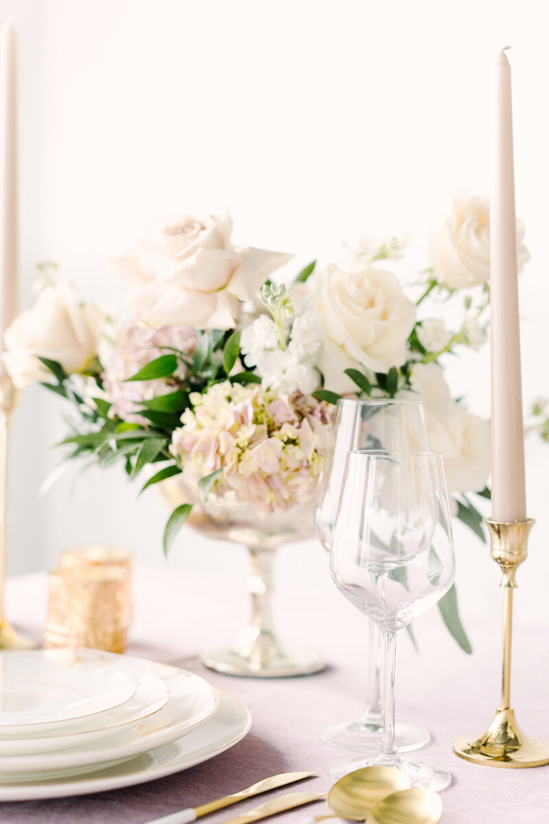 white roses in a vase on a pink table cloth