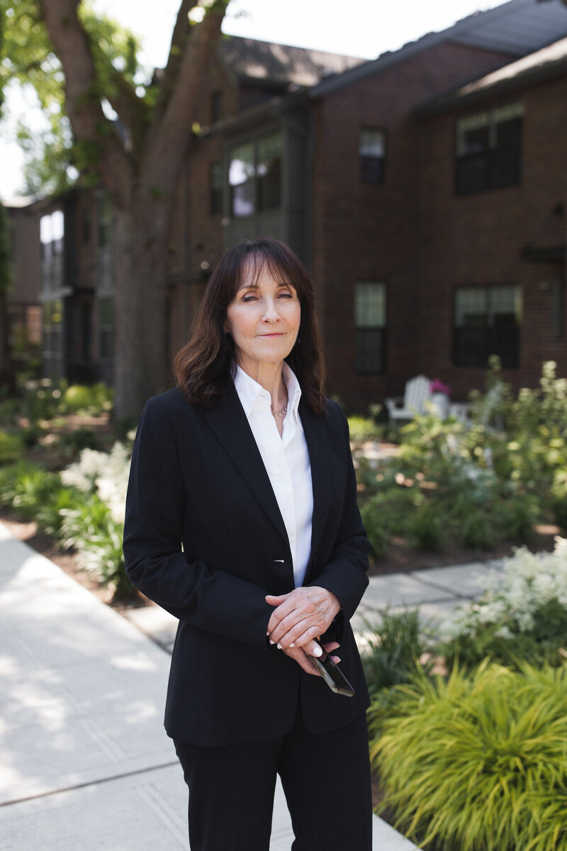 Seattle realtor portrait standing in front of a brick house