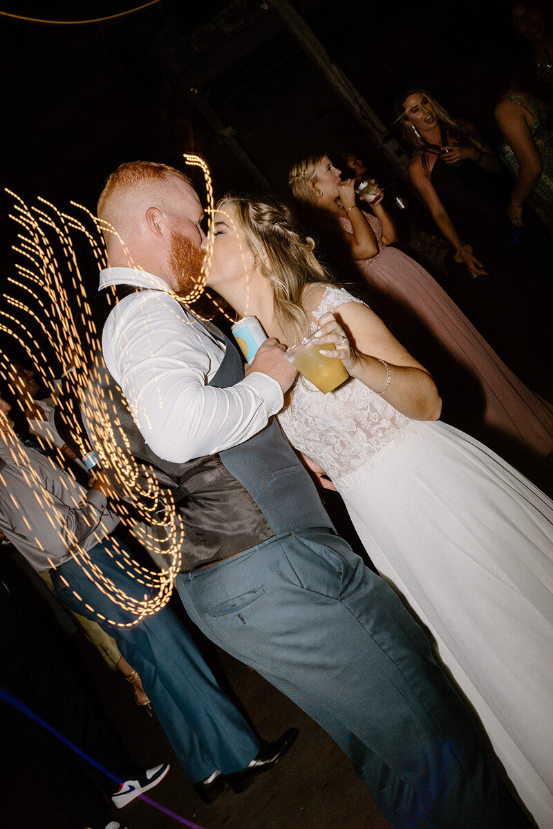 couple kissing and dancing at wedding reception