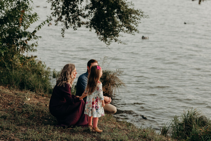 Denver family sitting by lake