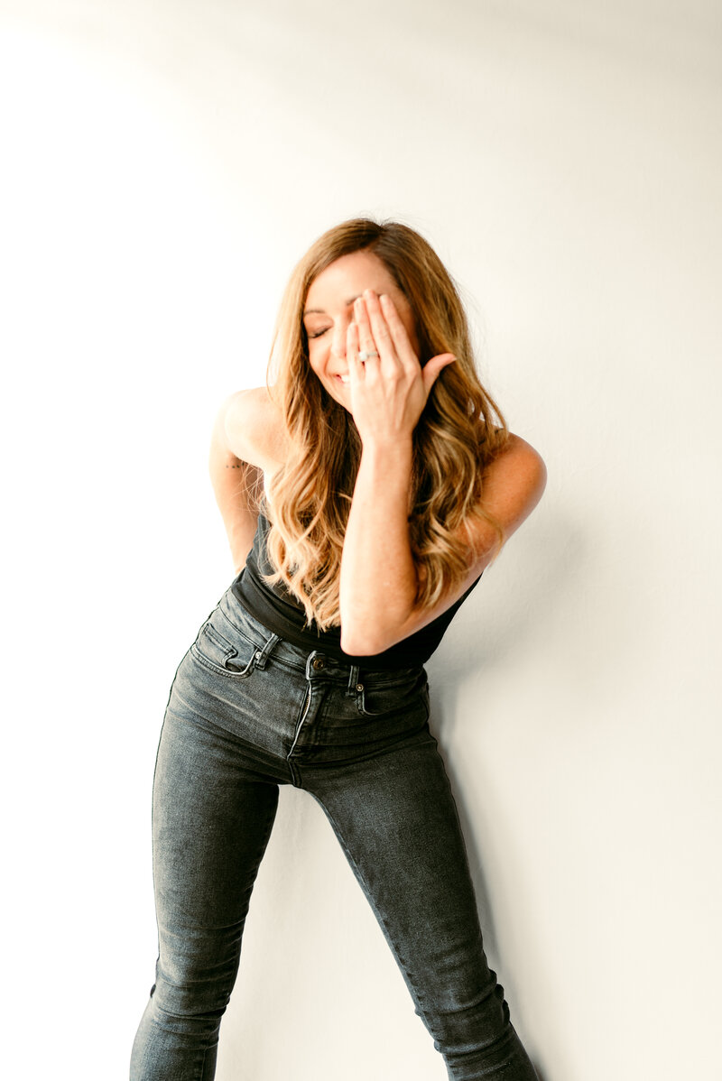 Candid portrait of Shannon O'Malley, Twin Cities portrait and online dating photographer, laughing naturally during a branding photo session, reflecting her fun and approachable style.