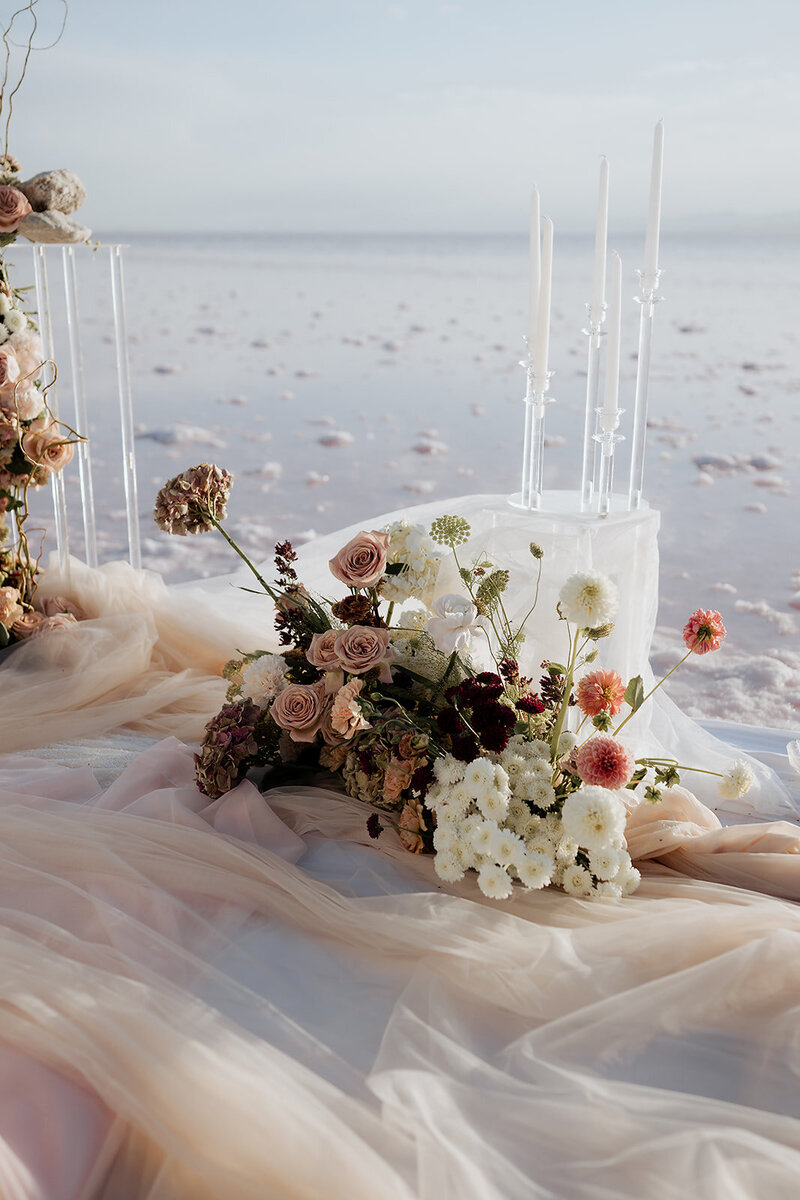 beautiful white and pink floral arrangement on a sandy pink lake