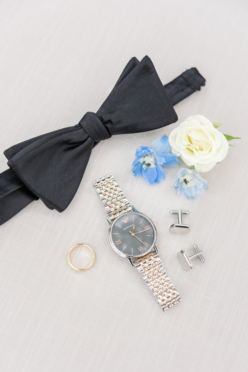 groom's bow tie, watch, wedding ring, and other wedding details
