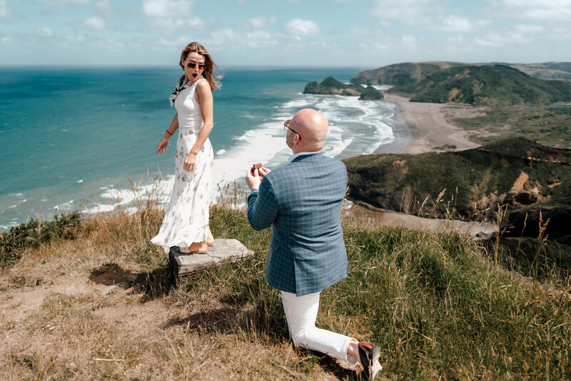 Man going down on his knee with the woman turning back in complete shock at a Helicopter Proposal in Auckland captured by Zanthe Vorsatz Photography