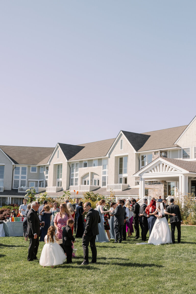 Group of wedding guests standing outside a large building.