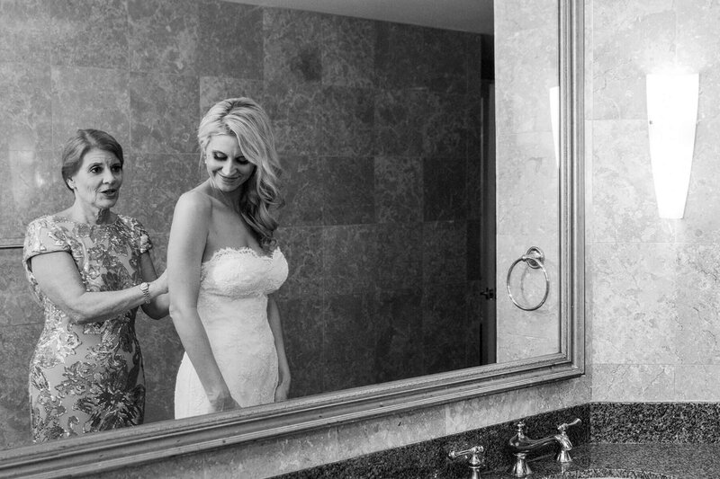 Black-and-white photo of a bride getting ready at the Riverside Hotel in Fort Lauderdale, photographed during the getting-ready portion of the First Look wedding timeline.