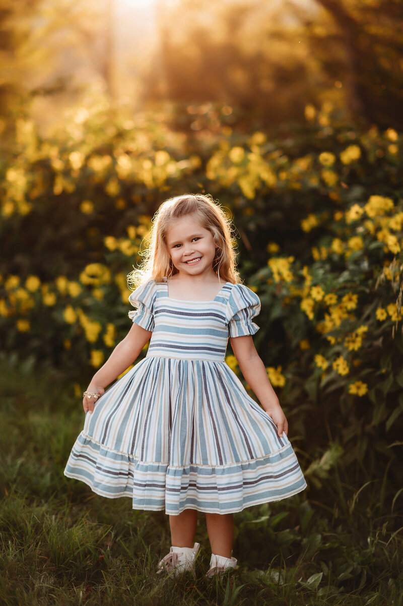 Little girls poses and smiles at the camera during Family Photos in Asheville, NC.