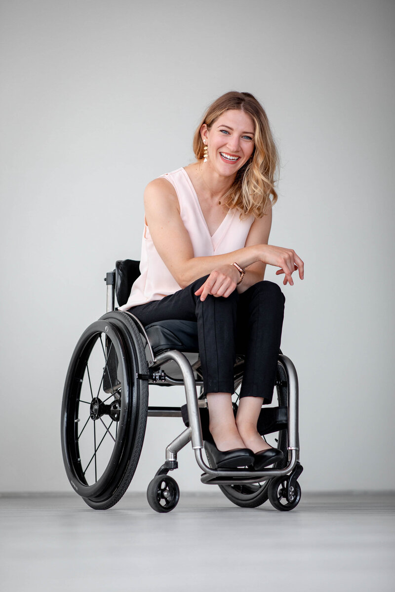 a woman in a wheel chair smiles at the camera in a studio space in Portland, OR