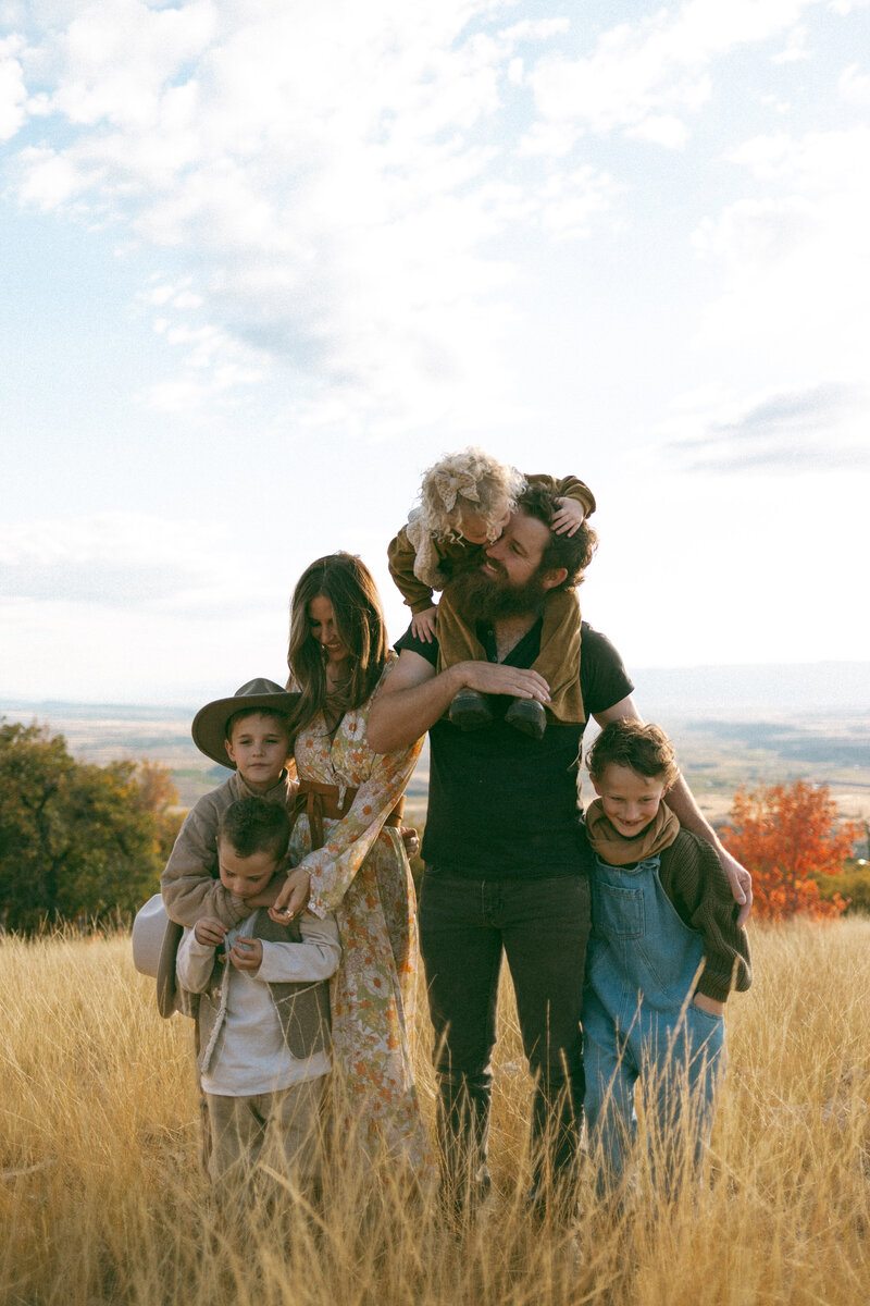 Mom and dad holding their toddler boy who is laughing and being silly.