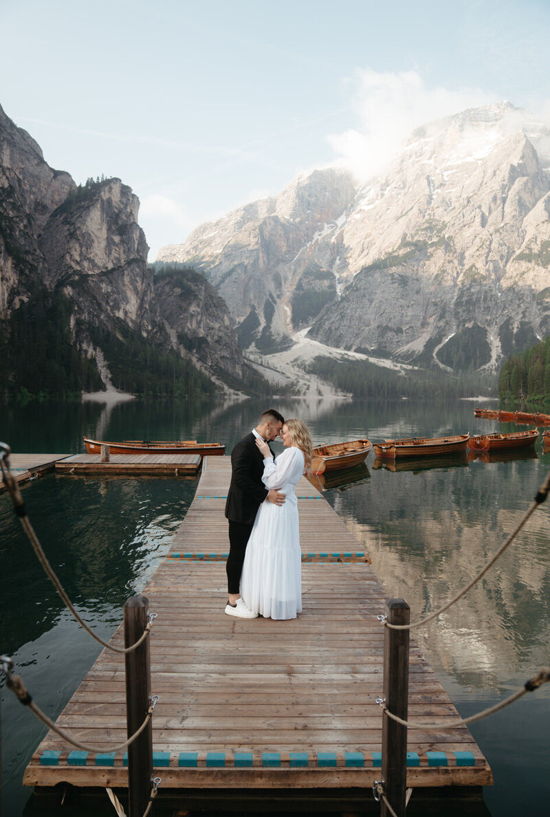 Lago di Braies dock perfectly frames a married kissing during their Dolomites Elopement