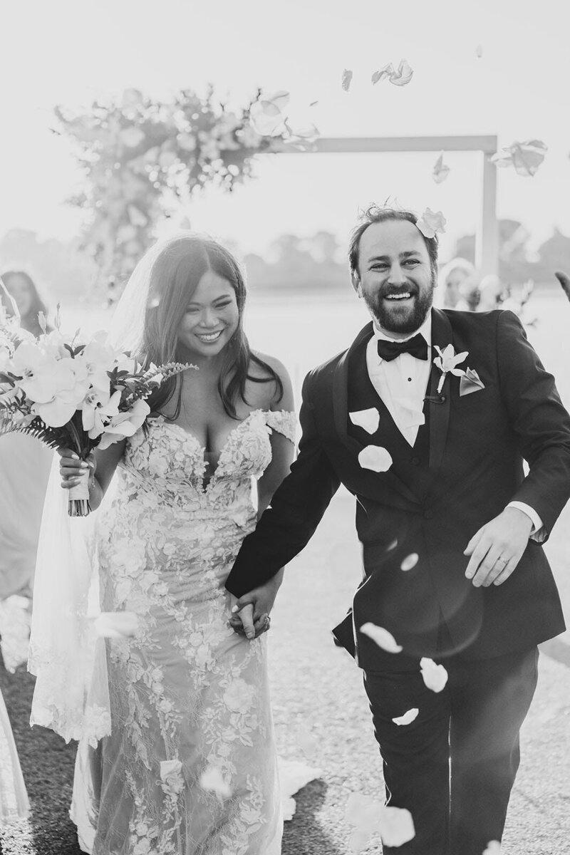 Bride and Groom walking down the aisle with flower petals tossed into the air