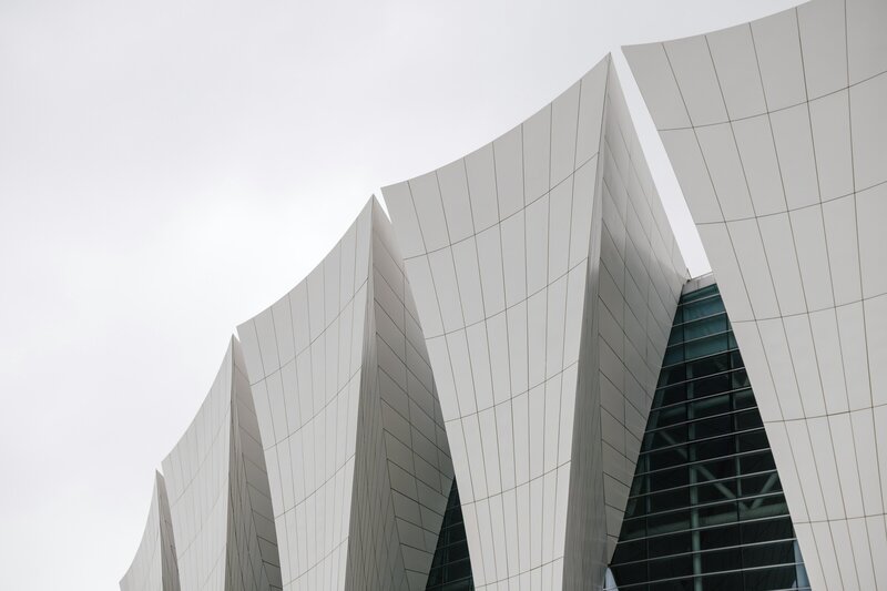 Four Pierce PR team members collaborate at a table, smiling and discussing a project on a laptop.